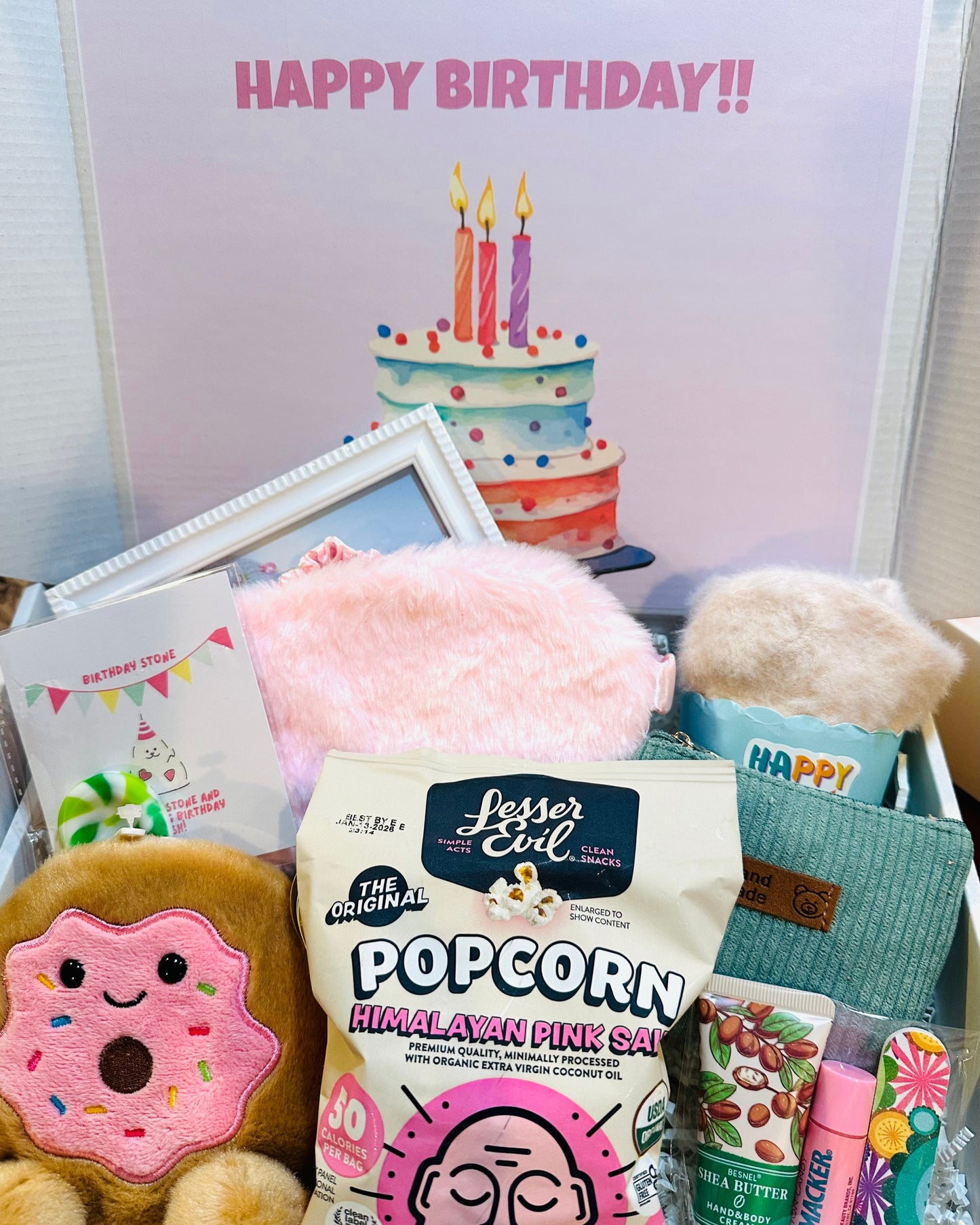 Birthday-themed items including popcorn, plush toys, and a card with a cake and candles.