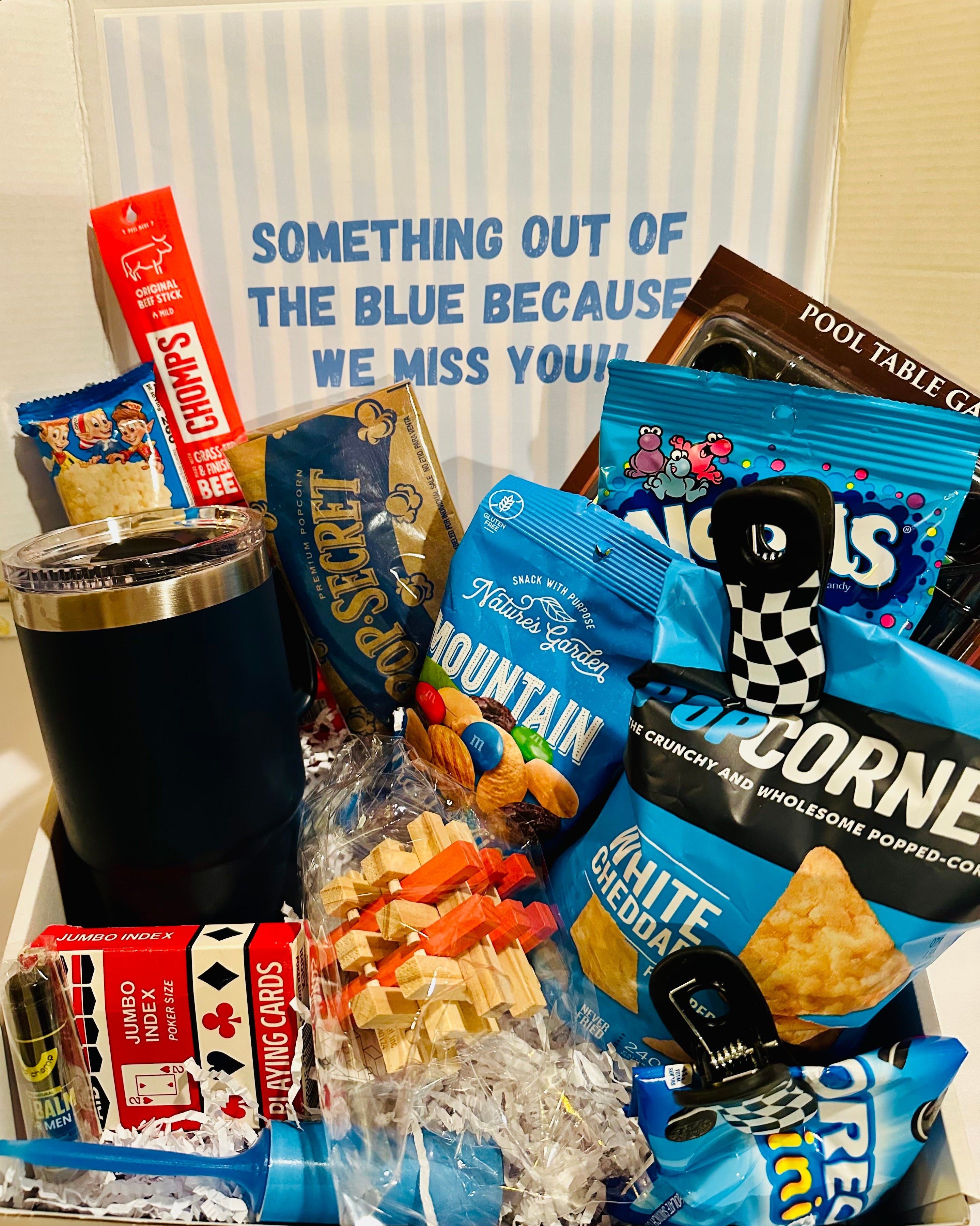 Assorted snacks and a tumbler on a table with a sign in the background.