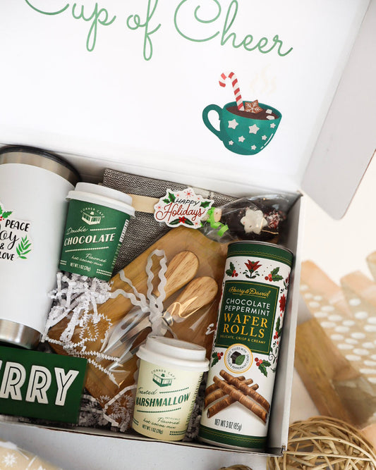 Gift box with holiday-themed items including a mug, cookies, and a jar of marshmallows.